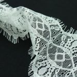 a close up of a white lace on a black background