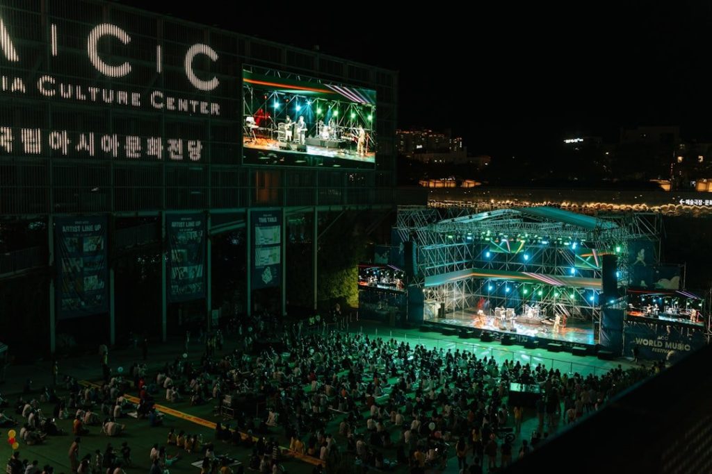 A square packed with spectators watching the performance even on a dark night