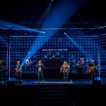 people standing on stage with blue lights