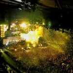 band playing on stage front of crowd during nighttime