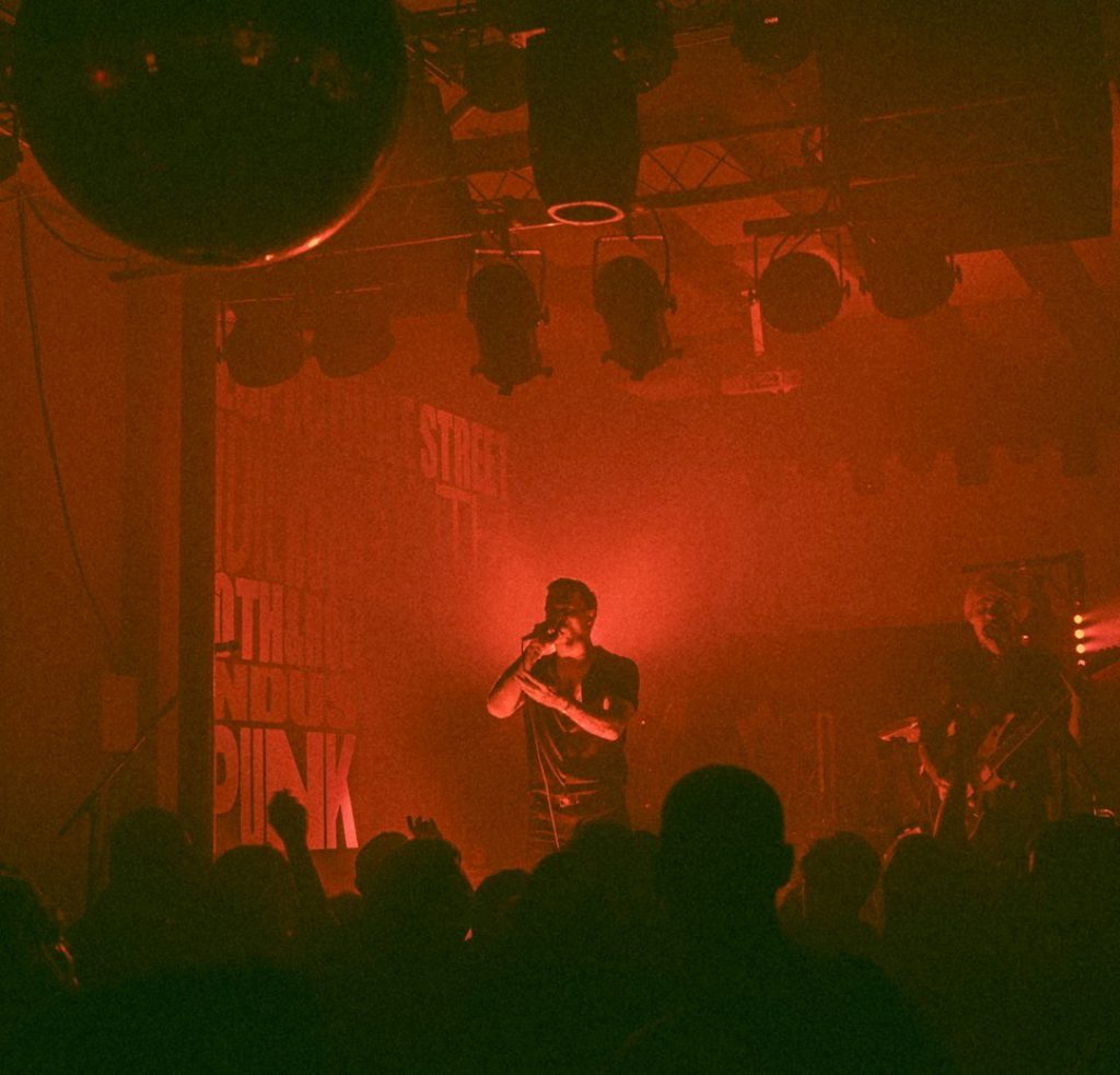 a person on a stage with a microphone in front of a crowd