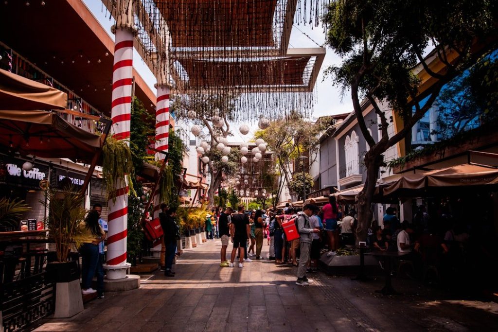 a group of people walking down a street next to tall buildings