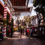 a group of people walking down a street next to tall buildings